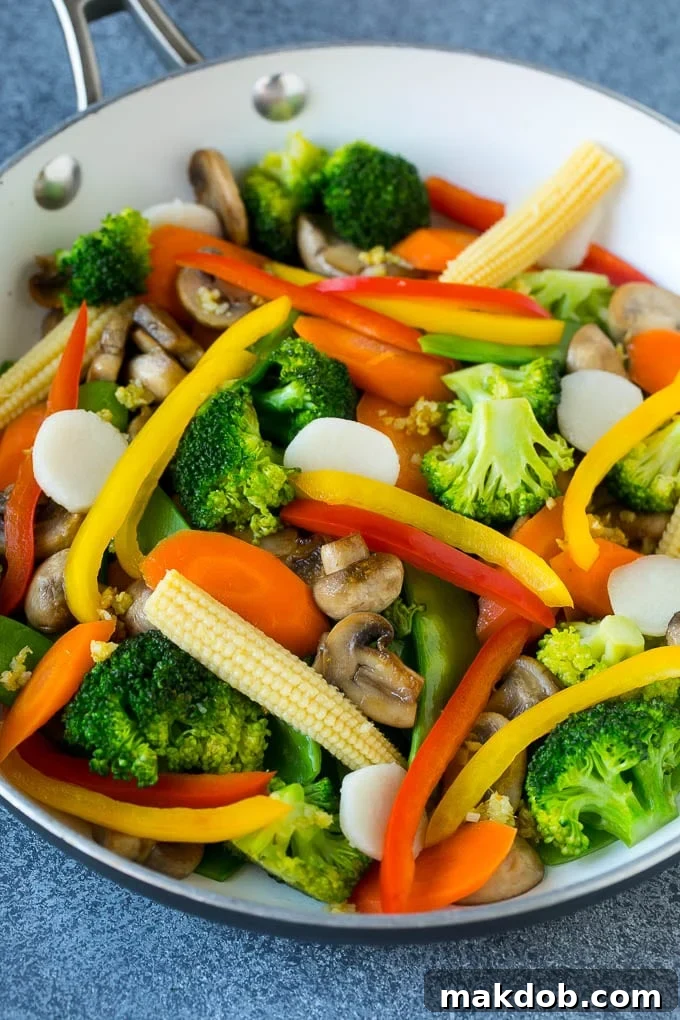 Vegetable Stir Fry Recipe | Veggie Stir Fry | Broccoli Stir Fry #vegetarian #vegetables #broccoli #dinner #dinneratthezoo A pan filled with a colorful medley of sautéed baby corn, water chestnuts, peppers, broccoli, and mushrooms, simmering in a flavorful sauce.