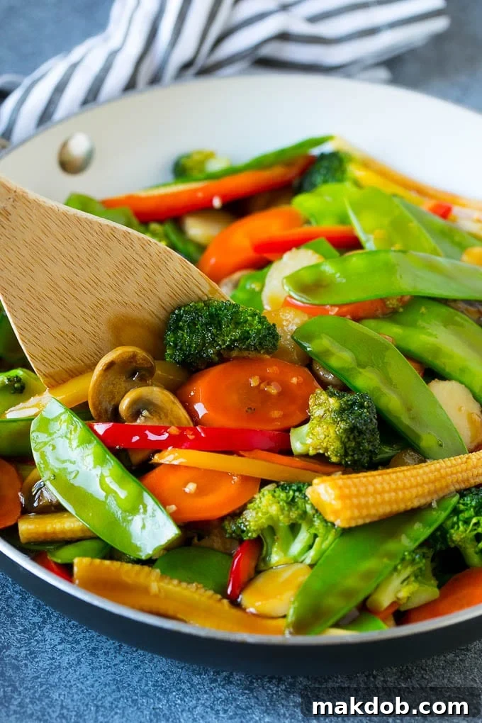 Vegetable Stir Fry Recipe | Veggie Stir Fry | Broccoli Stir Fry #vegetarian #vegetables #broccoli #dinner #dinneratthezoo A cooking spatula stirring a colorful pan of vegetable stir fry, featuring crisp carrots, tender snow peas, and vibrant broccoli florets.