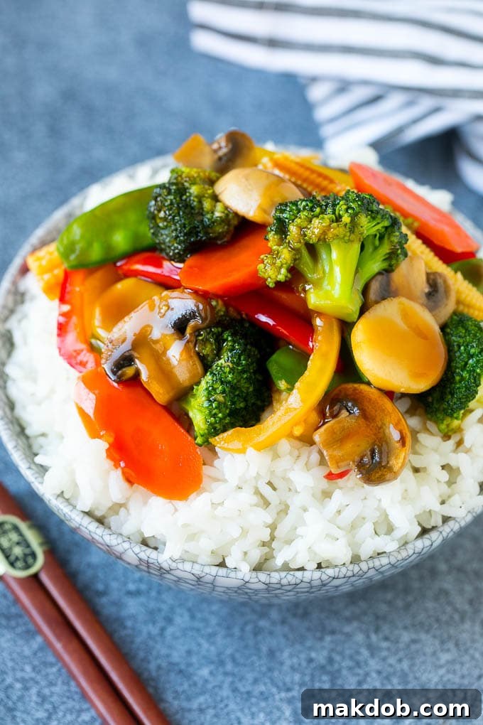 Vegetable Stir Fry Recipe | Veggie Stir Fry | Broccoli Stir Fry #vegetarian #vegetables #broccoli #dinner #dinneratthezoo A bowl of vibrant vegetable stir fry served over a bed of white rice, perfectly showcasing the colorful veggies and glossy sauce.