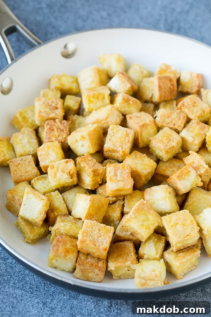 Cubes of crispy sauteed tofu in a skillet.