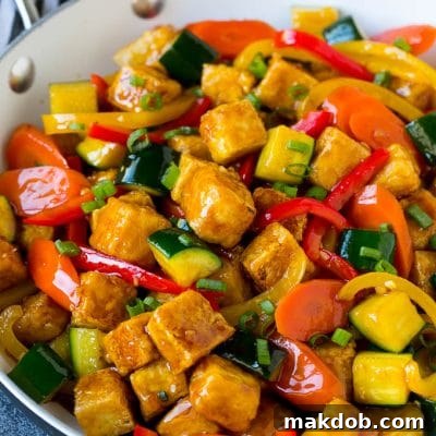 Tofu stir fry with peppers, carrots and zucchini in honey garlic sauce.