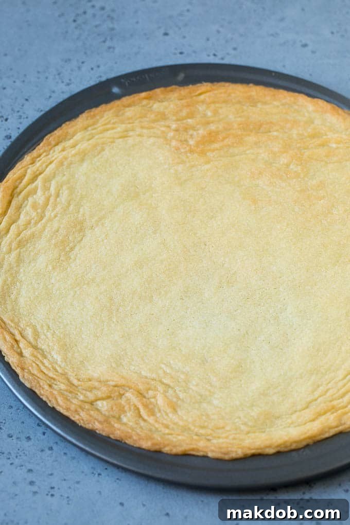 How to Make Fruit Pizza: Baking the Cookie Crust A sugar cookie baked inside a pizza pan, ready for frosting.