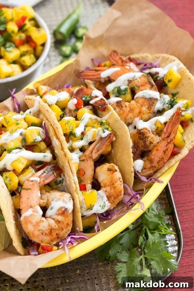 Three tacos filled with shrimp and a mango salsa.