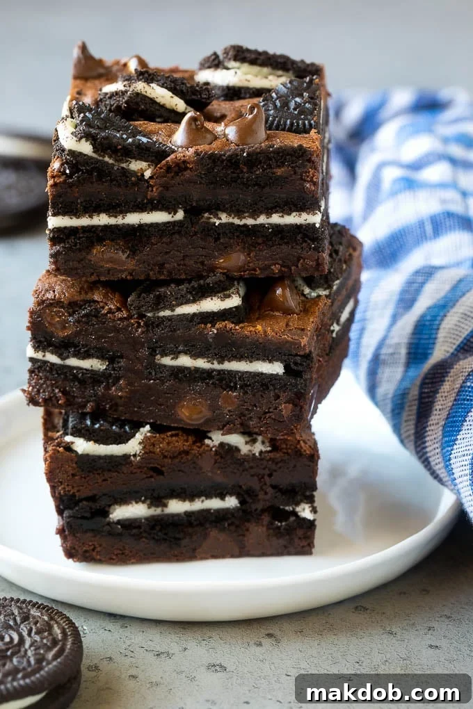 A stack of Oreo brownies filled with sandwich cookies and chocolate chips.