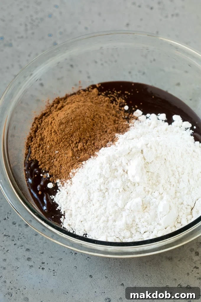 Melted chocolate, sugar, cocoa powder and flour in a mixing bowl.