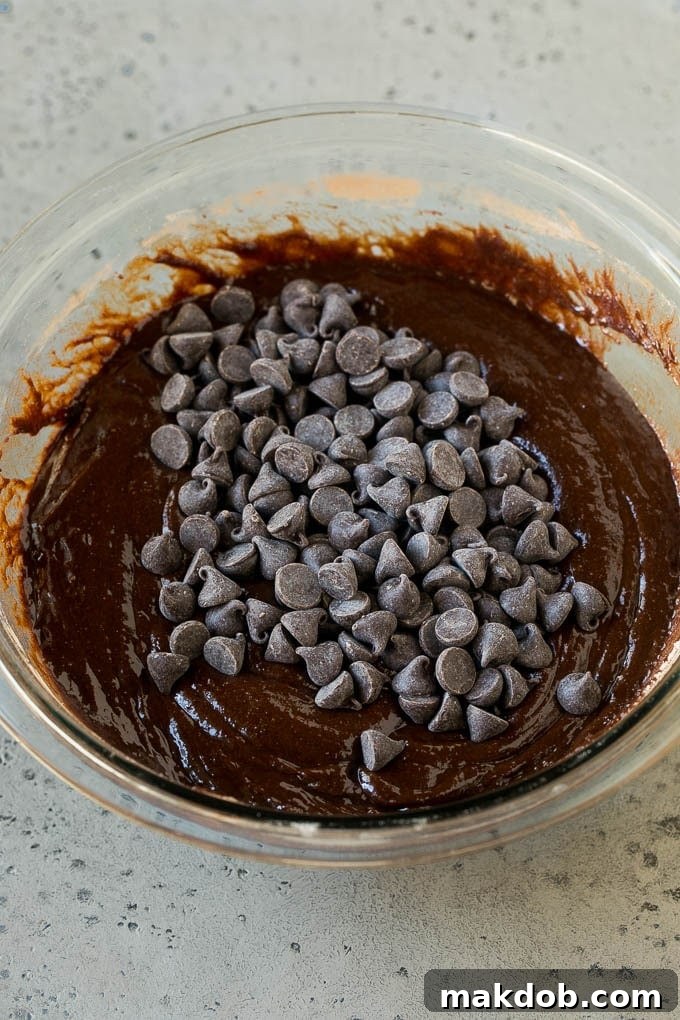 Chocolate brownie batter with chocolate chips in it.