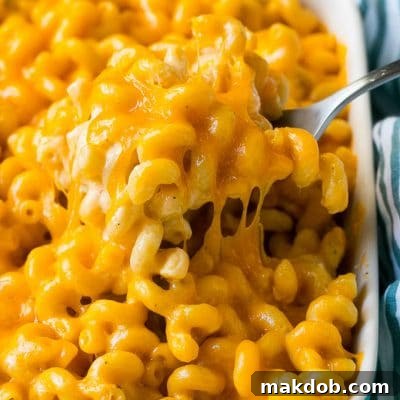 Golden Crusted Macaroni Perfection 2 Baked mac and cheese with a serving spoon lifting up a portion.