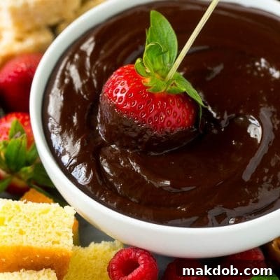 A strawberry on a skewer dipped into a bowl of chocolate fondue.