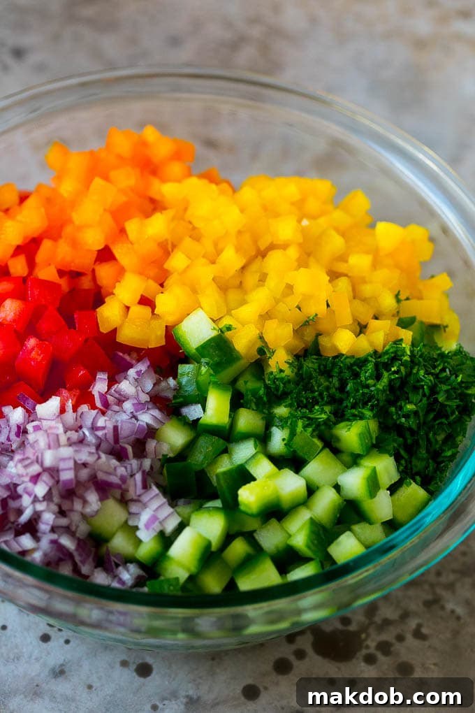Chopped peppers, cucumbers, tomatoes and onions in a bowl.