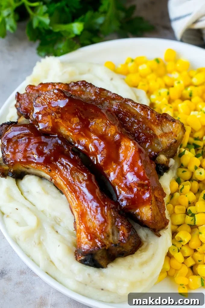 Slow cooker ribs served over mashed potatoes with corn.