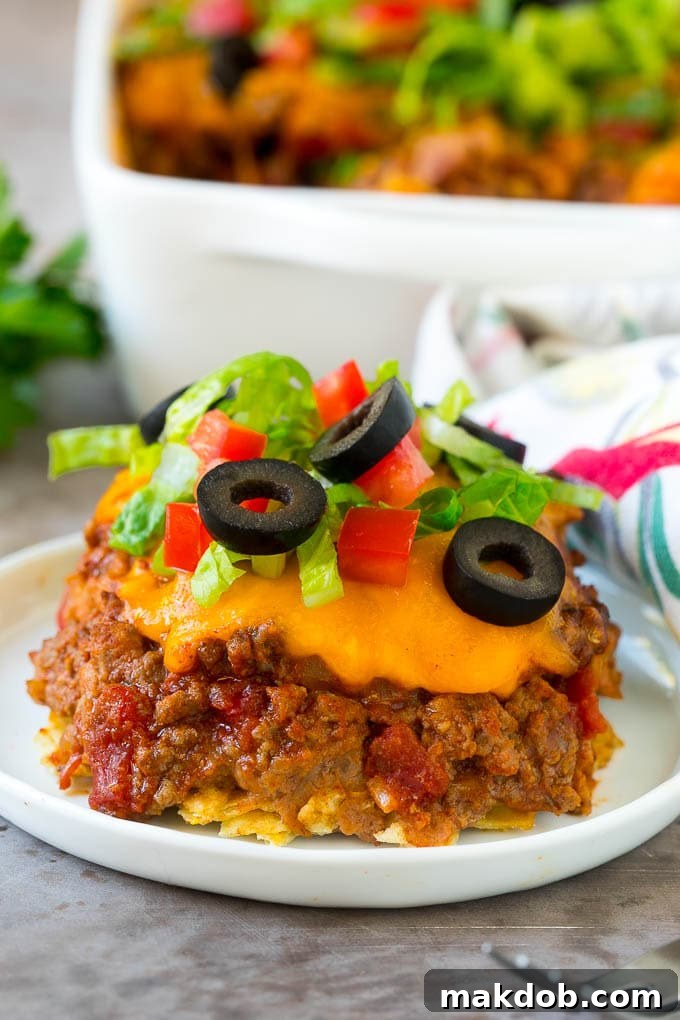 A warm, bubbling serving of taco casserole, crowned with beautifully melted cheese, presented on a plate.