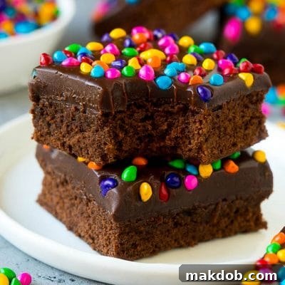 A stack of cosmic brownies on a plate with a bite taken out of one.