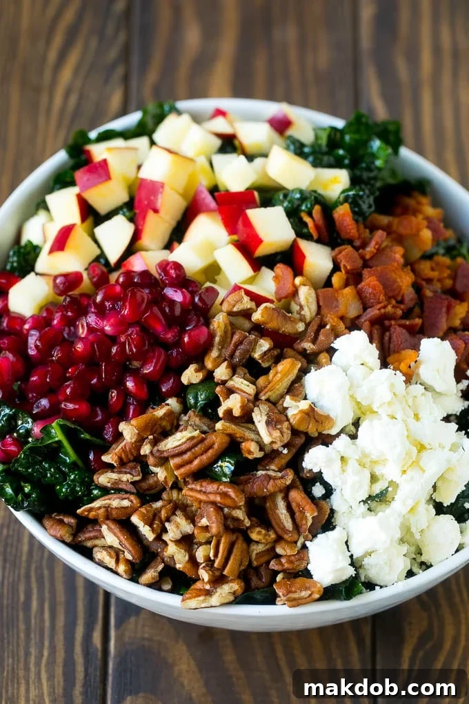 Kale salad topped with apples, bacon, pecans, pomegranate and feta cheese.
