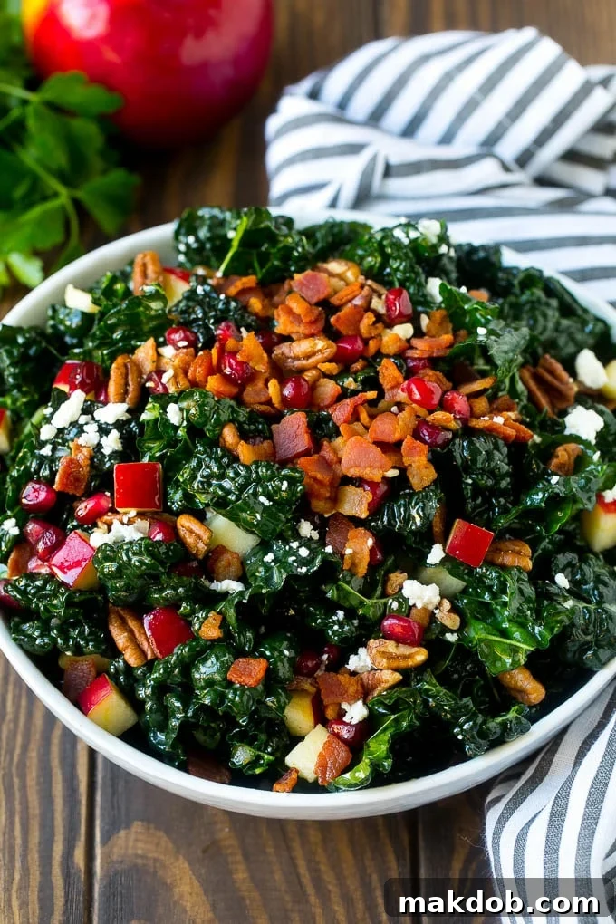 A bowl of tuscan kale salad garnished with cooked bacon.