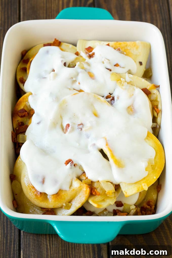 Pierogi Casserole Recipe | Potato Casserole #pierogis #casserole #bacon #cheddar #dinner #dinneratthezoo Dumplings in a baking dish covered with creamy sauce.