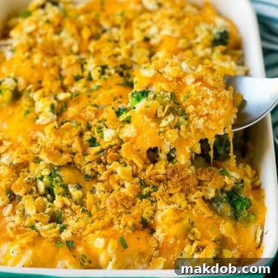Homestyle Chicken Bake 2 A spoon serving up a portion of chicken casserole made with rice and broccoli.