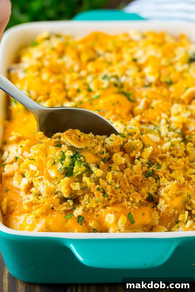 Serving Homemade Chicken and Rice Casserole A serving spoon lifting a generous portion of creamy chicken and rice casserole from a white baking dish, ready to be enjoyed.