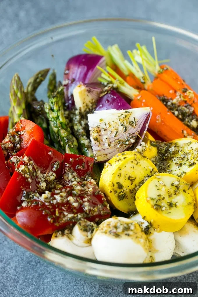Raw veggies in a bowl with garlic, herbs and olive oil, soaking in the marinade before being placed on the grill.