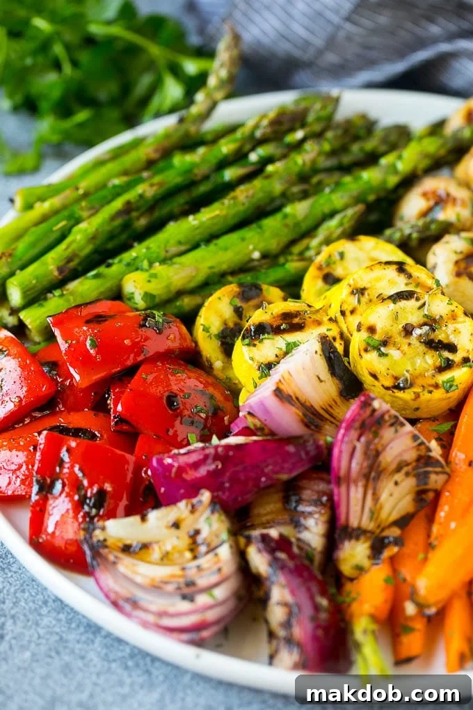 A platter of grilled veggies including peppers, onions, and carrots, ready to be served.