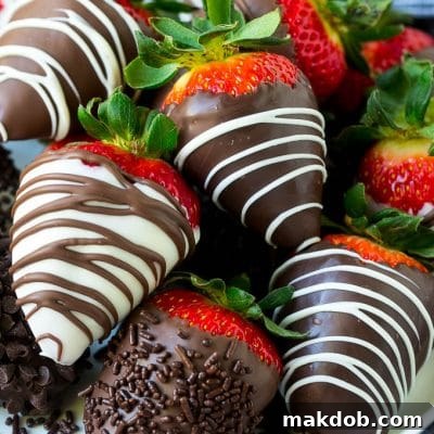 A plate of chocolate covered strawberries dipped in white and dark chocolate.