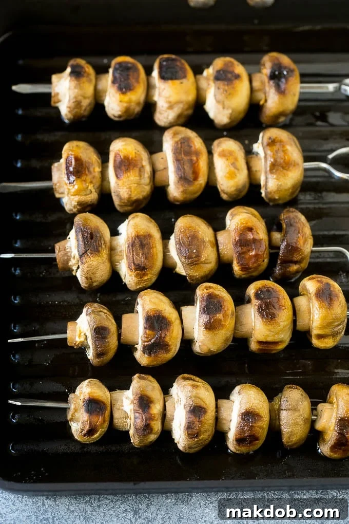 Grilled Mushrooms Recipe | Mushroom Kabobs | Mushroom Side Dish #mushroom #grilling #garlic #keto #lowcarb #dinneratthezoo Mushroom skewers cooked on a grill pan, showing delicious char marks.