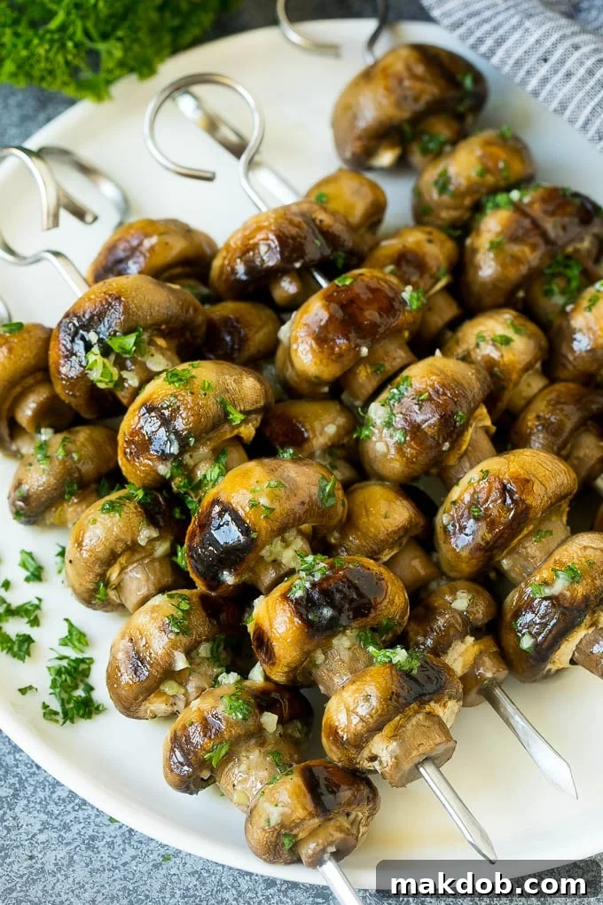 Grilled Mushrooms Recipe | Mushroom Kabobs | Mushroom Side Dish #mushroom #grilling #garlic #keto #lowcarb #dinneratthezoo Grilled mushrooms on skewers topped with glistening garlic butter, ready to be served.