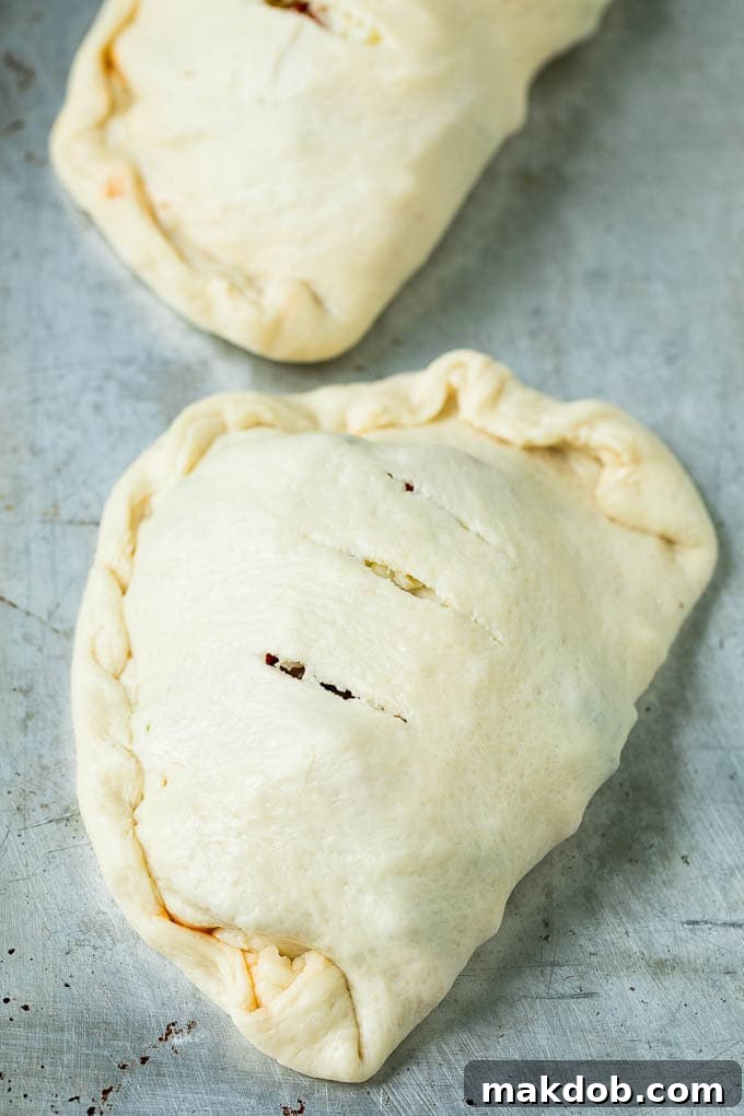 Calzone Recipe | Pizza Pockets #pizza #calzone #pepperoni #sausage #peppers #dinner #dinneratthezoo #cheese Unbaked calzones ready to go into the oven.