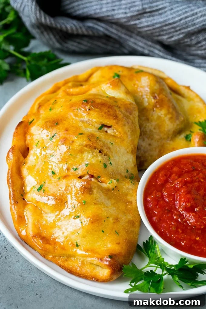 Calzone Recipe | Pizza Pockets #pizza #calzone #pepperoni #sausage #peppers #dinner #dinneratthezoo #cheese A homemade calzone served with pizza sauce.