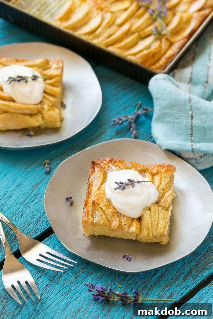 Spiced Apple Comfort Cake 5 A perfect slice of apple cinnamon cake on a small white plate, elegantly topped with a swirl of whipped cream.