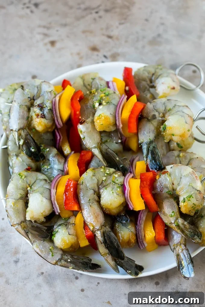 Raw shrimp on skewers with bell peppers and onions.