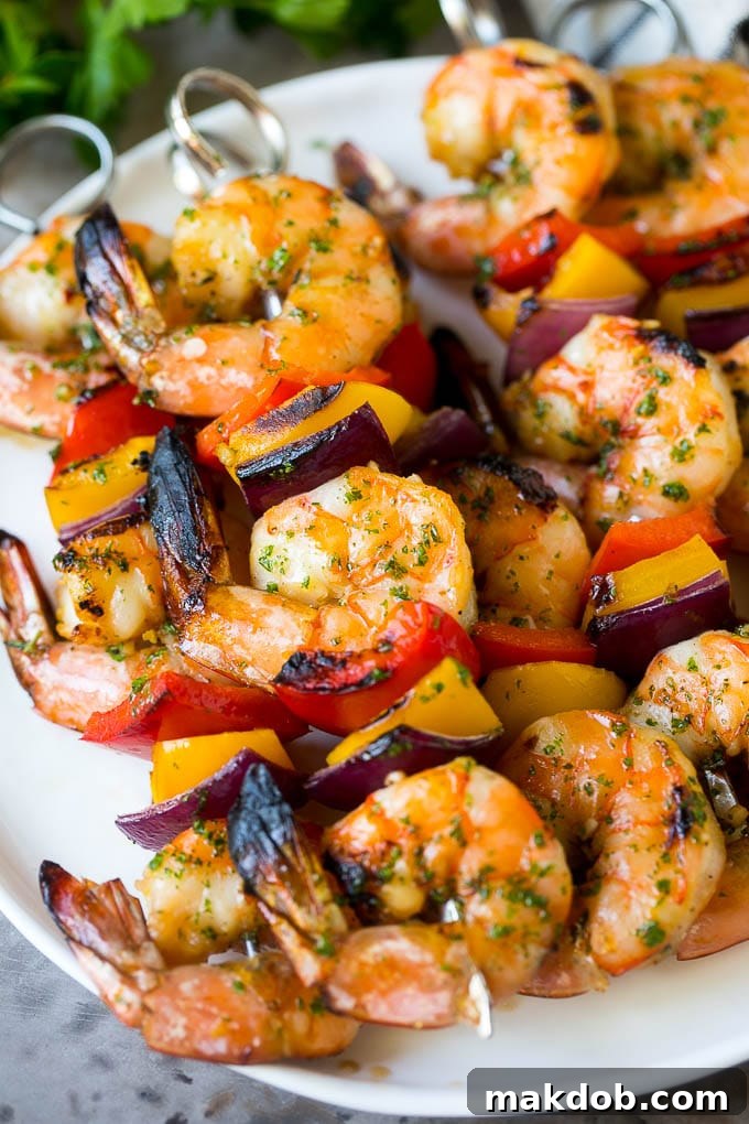 A plate of shrimp kabobs made with bell peppers and red onions.