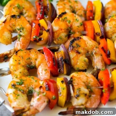 Shrimp kabobs with marinated grilled shrimp, red and yellow peppers and onions.