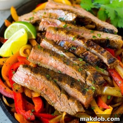 Steak fajitas served on a bed of seared peppers and onions.
