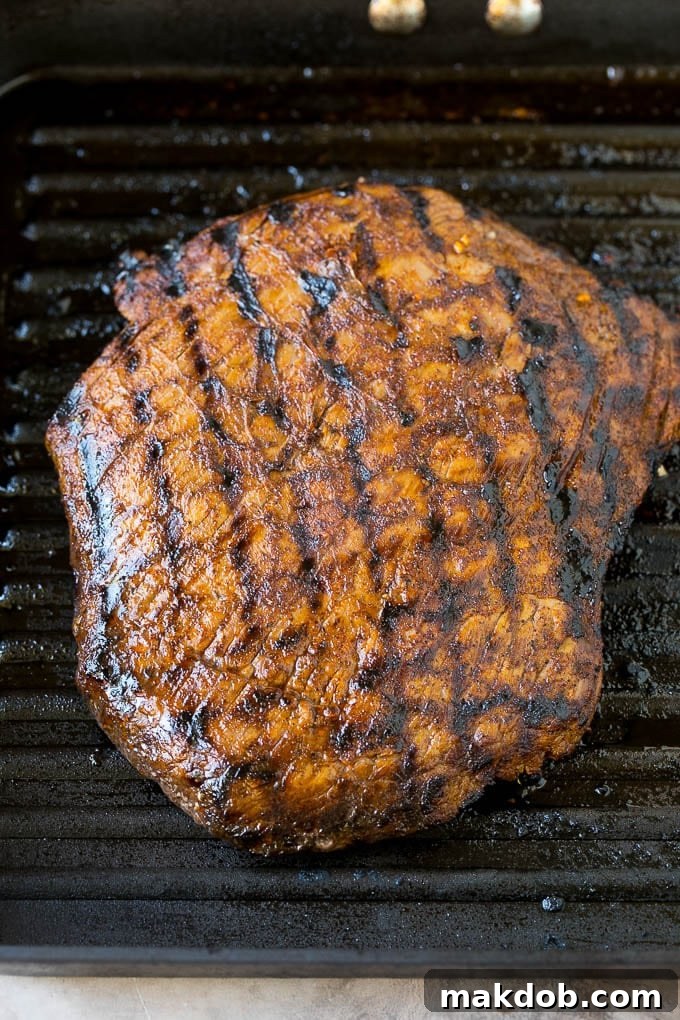 Grilled flank steak in a pan.