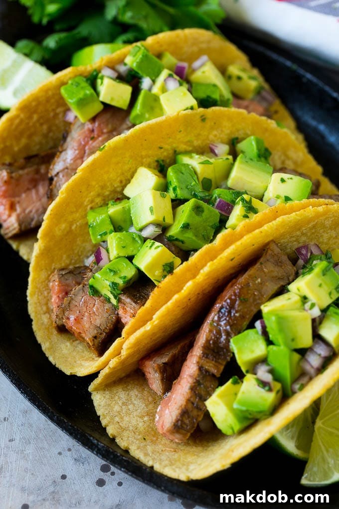 A platter of grilled steak tacos in corn tortillas.
