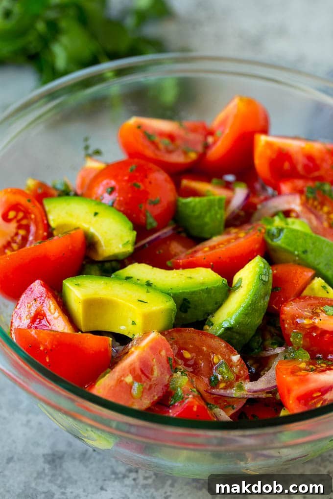 Healthy Avocado Tomato Salad | Easy Meal Prep | Fresh Ingredients A beautifully presented bowl of avocado salad with vibrant tomatoes and thinly sliced red onion, ready for a healthy meal.