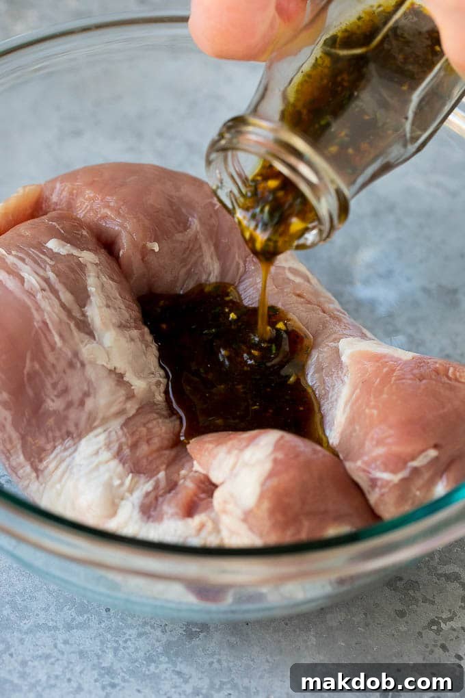 Marinated Pork Tenderloin Recipe | Pork Tenderloin Marinade | Pork Marinade #pork #porktenderloin #marinade #dinner #grilling #dinneratthezoo Marinade being poured over pork tenderloin.