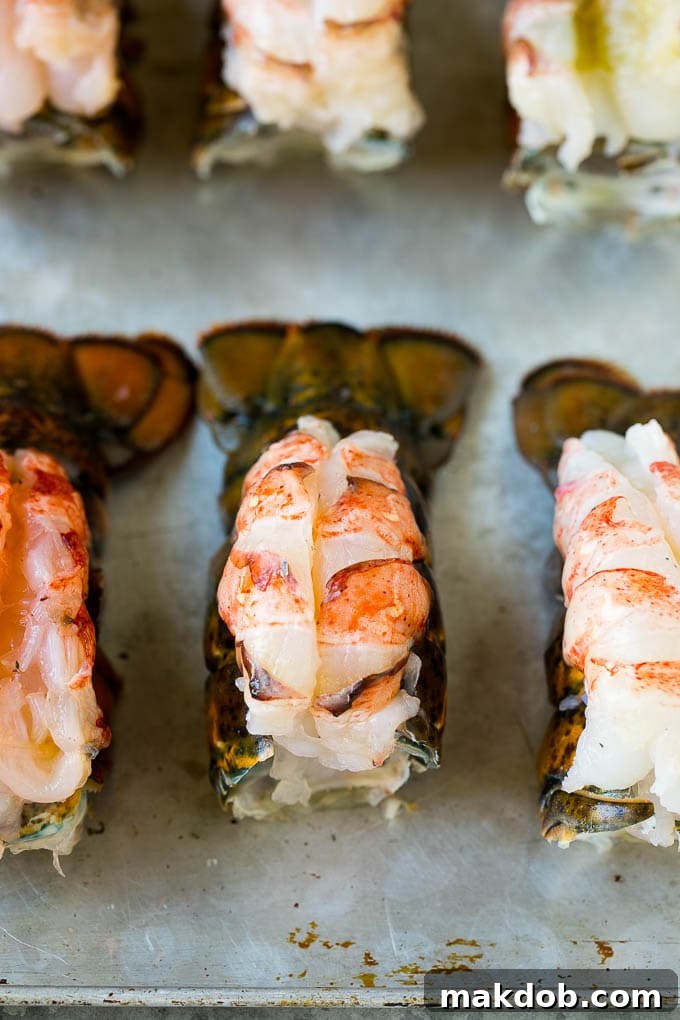 Raw lobster meat butterflied and fanned out on top of lobster shells, ready for seasoning.