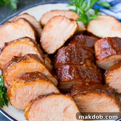 Smoked pork tenderloin sliced on a serving plate.