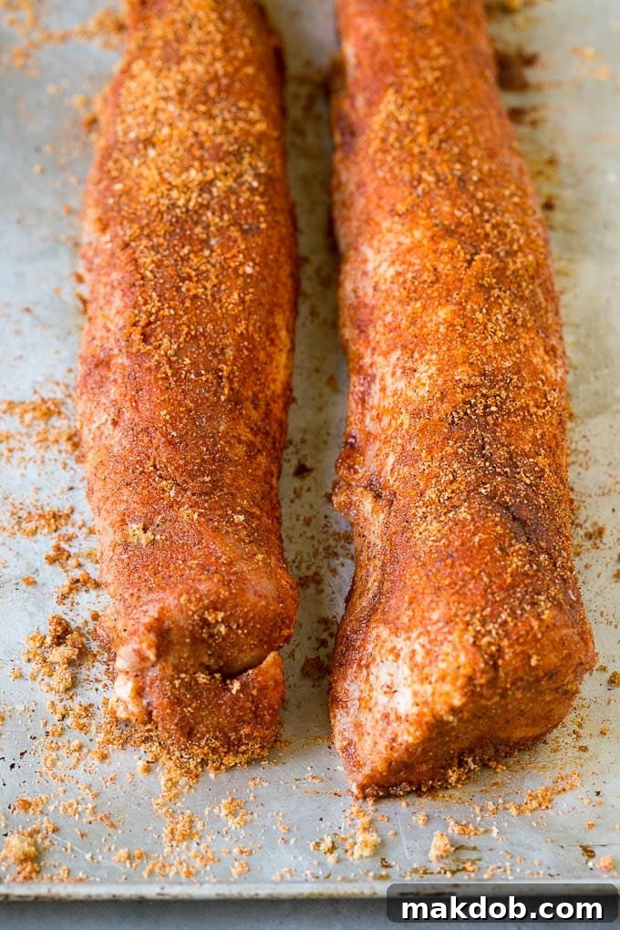 Pork tenderloins generously coated in a flavorful homemade spice rub, ready for the smoker.