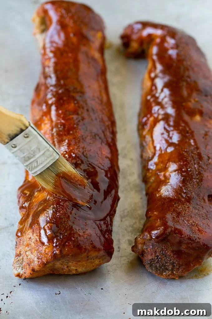 BBQ sauce being generously brushed over smoked pork loin, adding a luscious glaze.
