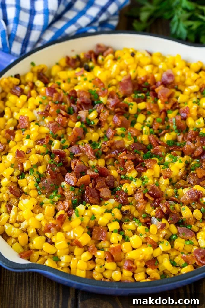 Savory Bacon Corn Skillet 2 Fried corn topped with bacon and chives in a pan.
