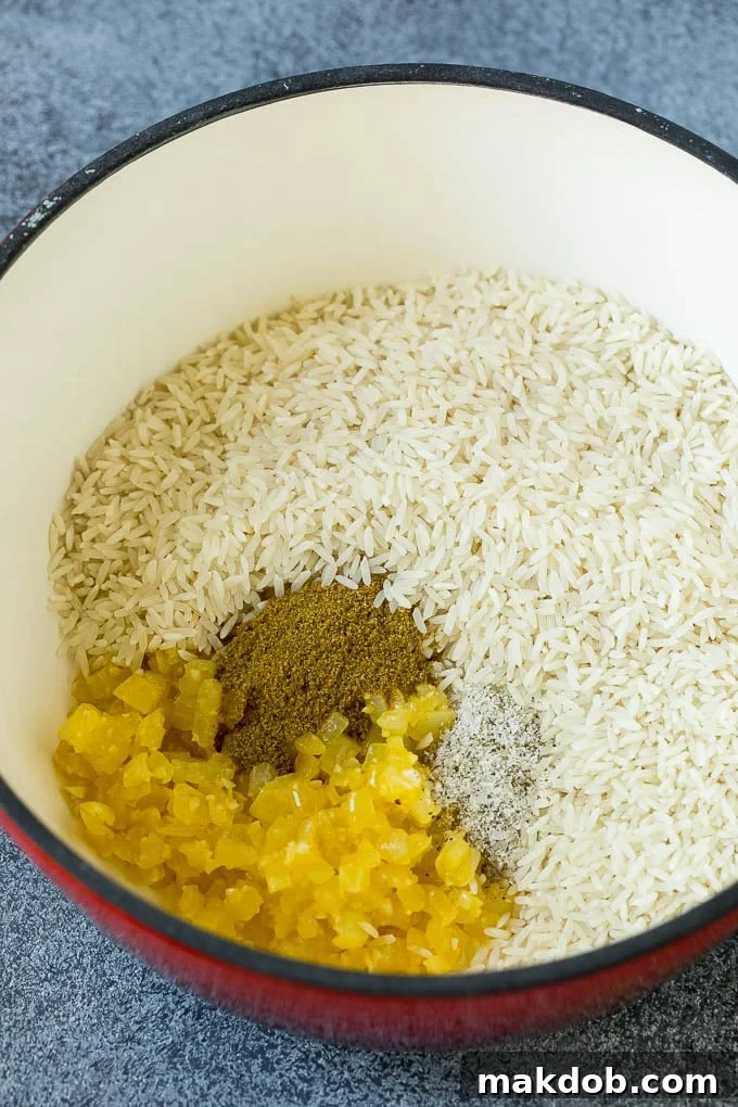 Black Beans and Rice Recipe | Cuban Black Beans | Beans and Rice #beans #rice #blackbeans #glutenfree #dinner #dinneratthezoo Onions, garlic, white rice and spices in a pot.