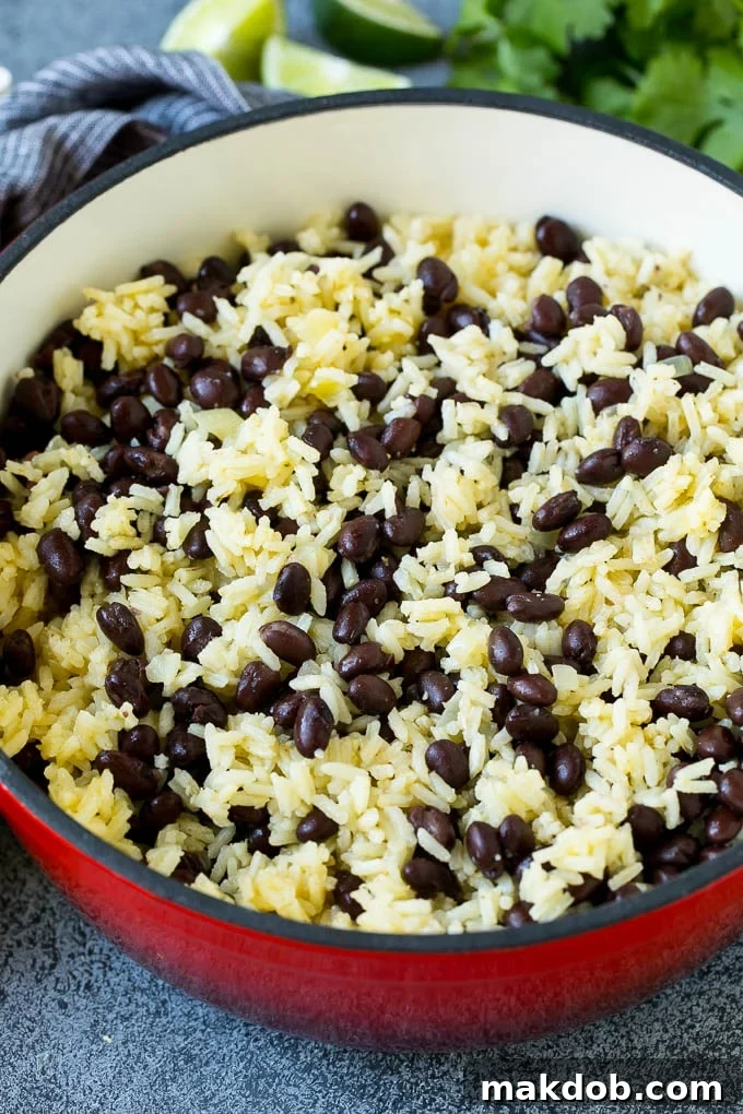 Black Beans and Rice Recipe | Cuban Black Beans | Beans and Rice #beans #rice #blackbeans #sidedish #glutenfree #dinner #dinneratthezoo Rice and beans mixed together in a red pot.