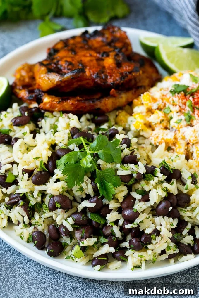 Black Beans and Rice Recipe | Cuban Black Beans | Beans and Rice #beans #rice #blackbeans #sidedish #glutenfree #dinner #dinneratthezoo A plate of black beans and rice with grilled pork and Mexican corn.