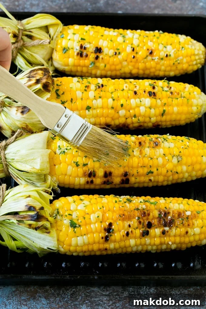 Cobs being brushed with herb butter.