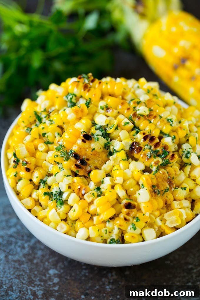 Grilled corn cut off the cob with herb butter in a bowl.