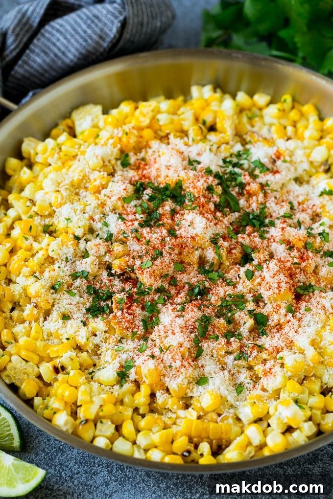 Mexican street corn, or Esquites, served in a bowl, topped with cotija cheese, chili powder, and fresh cilantro.