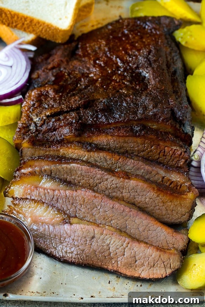 Perfectly smoked brisket, thinly sliced and served with pickles, onions, and fresh bread, ready to be enjoyed.