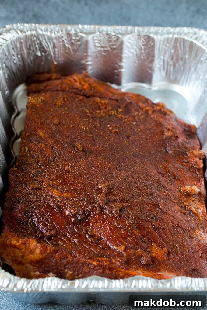 Raw beef brisket generously coated in a homemade spice rub, ready for smoking.